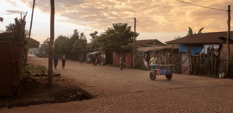 Ethiopia boy pulling handcart past electricity poles 